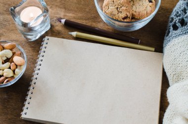 Düz örme battaniye ve ahşap masa snacks boş kahverengi defter yatırın. Sonbahar ya da kış ruh rahat. Kopya alanı.