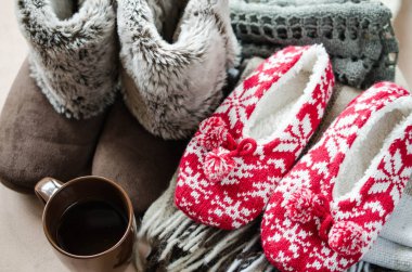 Sıcak ev kıyafetleri. Yünlü ekose kumaş, terlik ve bir fincan sıcak içecek..