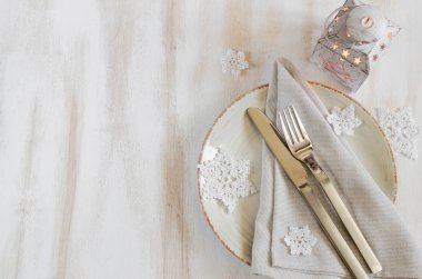 Xmas süslemeleri Vintage ya da Provence stili ile fener ile Noel tablo yer ayarı. Gümüş keten peçete ve rustik ahşap zemin üzerine dekoratif kar taneleri ile. Üstten görünüm. Kopya alanı.