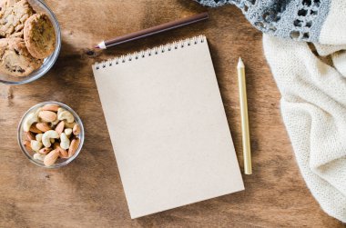 Düz örme battaniye ve ahşap masa snacks boş kahverengi defter yatırın. Sonbahar ya da kış ruh rahat. Kopya alanı.