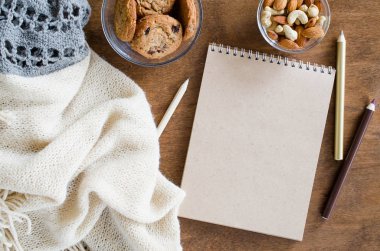 Düz örme battaniye ve ahşap masa snacks boş kahverengi defter yatırın. Sonbahar ya da kış ruh rahat. Kopya alanı.