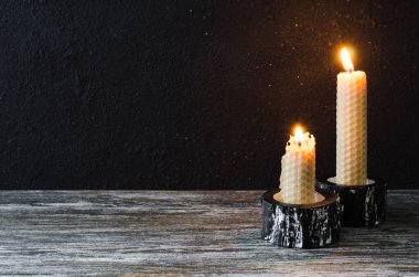 Eski bir ahşap masa üzerinde yanan mum. Mistik koyu arka plan.