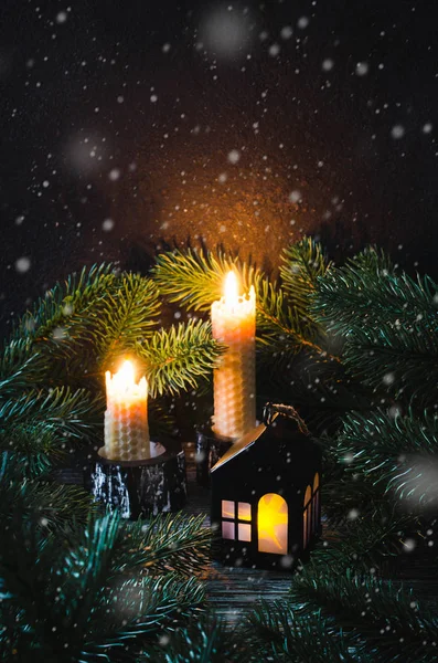 Juguete de Navidad casa y dos velas entre el abeto . —  Fotos de Stock