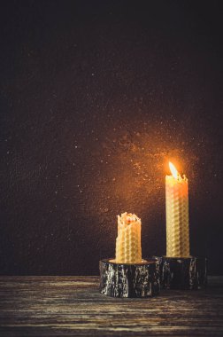 Eski bir ahşap masa üzerinde yanan mum. Karanlık mistik arka plan. Kopya alanı.