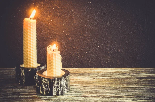 Eski bir ahşap masa üzerinde yanan mum. Karanlık mistik arka plan. Kopya alanı.