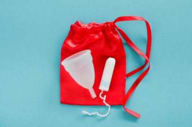 Kadın hijyen ürünleri - adet Kupası ve tampon mavi bir arka plan üzerinde farklı türleri. Seçici odak
