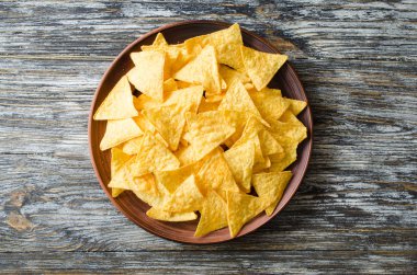 Ahşap bir masa üzerinde bir plaka nachos mısır cipsi. Meksika yemeği kavramı. Üstten görünüm.