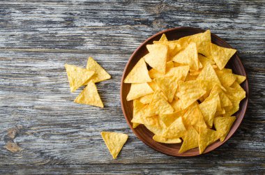 Ahşap bir masa üzerinde bir plaka nachos mısır cipsi. Meksika yemeği kavramı. Üstten görünüm.