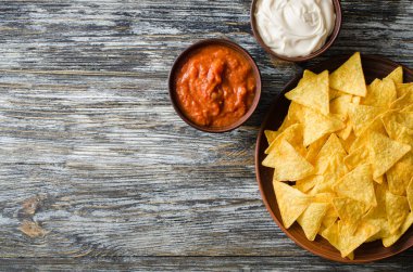 Cips mısır cipsi baharatlı domates ve peynir soslar. Meksika yemeği kavramı. Sarı Mısır salsa sosu totopos patatesler. Üstten görünüm.