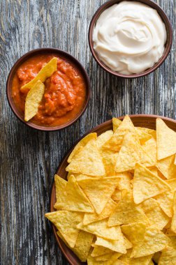 Cips mısır cipsi baharatlı domates ve peynir soslar. Meksika yemeği kavramı. Sarı Mısır salsa sosu totopos patatesler. Üstten görünüm.