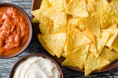 Cips mısır cipsi baharatlı domates ve peynir soslar. Meksika yemeği kavramı. Sarı Mısır salsa sosu totopos patatesler. Üstten görünüm.