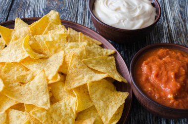 Cips mısır cipsi baharatlı domates ve peynir soslar. Meksika yemeği kavramı. Sarı Mısır salsa sosu totopos patatesler. Üstten görünüm.