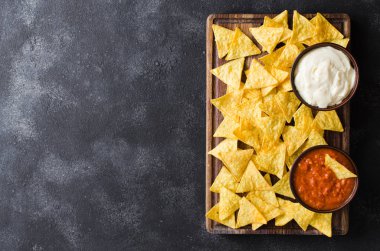 Cips mısır cipsi baharatlı domates ve peynir soslar. Meksika yemeği kavramı. Sarı Mısır salsa sosu totopos patatesler. Üstten görünüm.