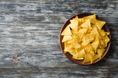 Nachos mısır cipsi tahta bir masanın üzerindeki tabakta. Meksika gıda kavramı.