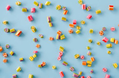 Mavi arka planda dağınık çok renkli şeker şekeri