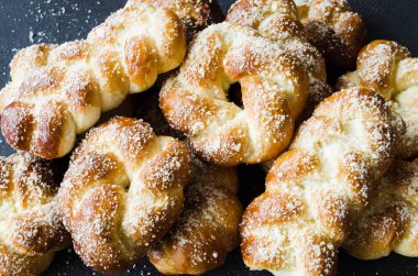 Fırında taze kokulu çörekler. Geleneksel ev yapımı hamur işleri. Pigtail çörekler üst görünümü.