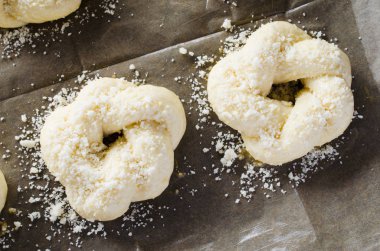 Hazırlık süreci - çiğ unbaked çörekler. Pişirme kağıdı üzerinde ev yapımı geleneksel çörekler pişirmeye hazır.