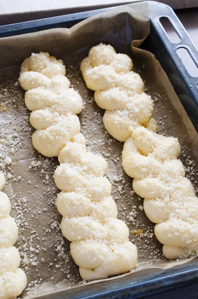 Processo de preparação - pães crus não cozidos. Pães de massa de levedura em papel manteiga, close-up . — Fotografia de Stock