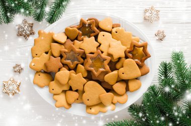 Beyaz arka planda buzlanma ile süslemek için hazır taze pişmiş Noel Gingerbread dolu plaka.