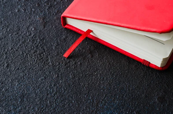 Червоний закритий блокнот для написання або книги на темному фоні — стокове фото