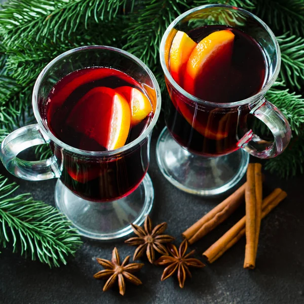 Noël vin rouge chaud avec des épices sur fond sombre — Photo