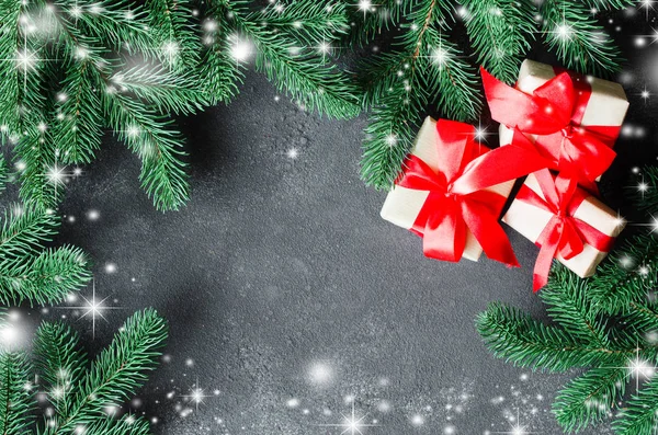 Weihnachtsgeschenke und Tannenbaum auf dunklem Hintergrund. — Stockfoto