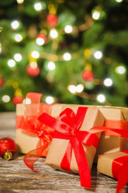 Noel ağacı ve parıldayan parti ışıkları bokeh arka plan karşı Noel hediye kutuları.