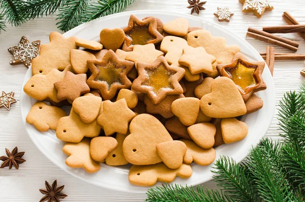 Placa llena de pan de jengibre de Navidad recién horneado sobre fondo de madera blanca . —  Fotos de Stock