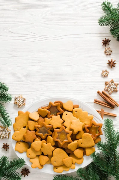 Teller voller frisch gebackener Weihnachts-Lebkuchen mit Zuckerguss auf weißem Holzgrund. — Stockfoto