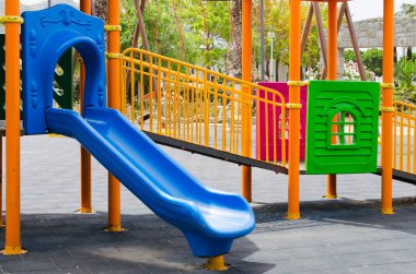 Yeşil ağaçlarla çevrili parktaki boş çocuk parkı aktiviteleri.