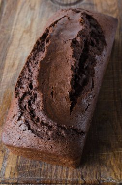 Taze pişmiş ev yapımı çikolatalı ekmek ya da ahşap tahta üzerinde pasta, köy usulü. Seçici odak, üst görünüm.