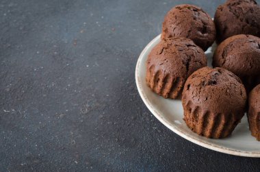 Koyu arkaplanda bir tabak dolusu çikolatalı kek. Lezzetli çikolatalı tatlı. Boşluğu kopyala.