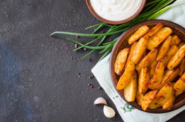 Altın baharatlı patates kızartması ya da sarımsak, sos ve soğanla pişirilmiş fırın. Köy tarzında lezzetli, lezzetli, çıtır çıtır atıştırmalıklar. Üst görünüm.