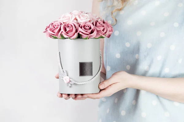 Decoración de la boda: la chica en un vestido de globo sostiene una caja redonda con un ramo de rosas rosadas . — Foto de Stock