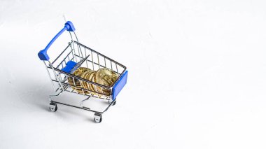 Kripto para ödemek: süpermarket arabası bitcoin beyaz bir arka plan üzerinde altın sikkeleri ile doldurulur. Yakın çekim. Kopya alanı