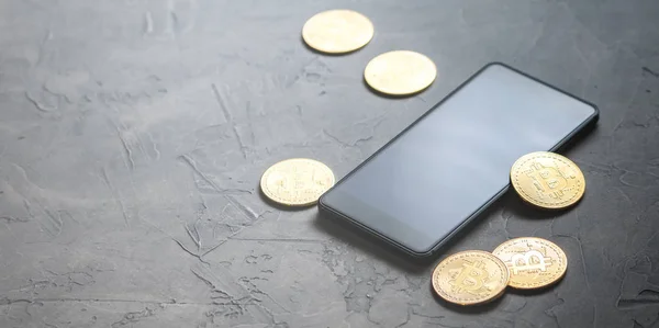 Kripto-para kazanç: altın paralar bitcoin ve gri arka plan üzerinde smartphone. Yatay çerçeve.