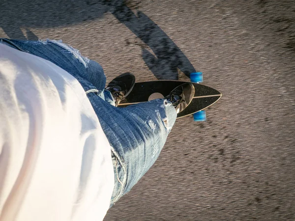 Straat sport: de man rolt op de longboard op het asfalt. First person view. — Stockfoto