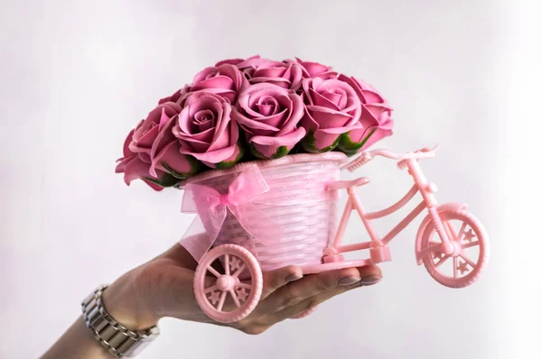 Decoración floral festiva: una pequeña cesta decorativa en forma de forbike con brotes de flores rosadas sobre un fondo blanco . — Foto de Stock