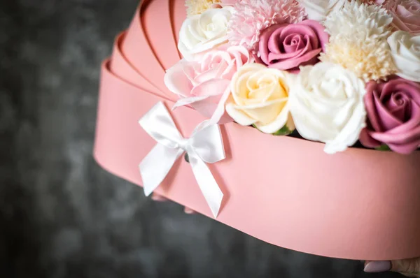 Felicitaciones por el nacimiento del bebé: Caja rosa con capullos de flores multicolores en forma de cuna . — Foto de Stock