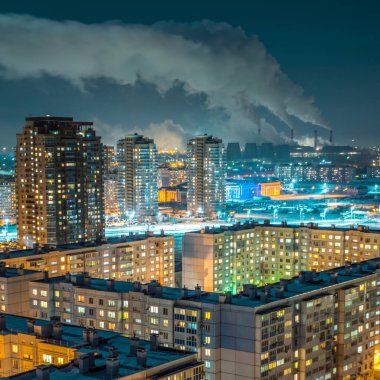 Gece şehir: parlak ve şehrin çatısı görünümünden zıt. Ufukta, bitki yüksek boru duman.