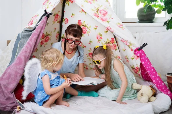 Czas dla rodziny: Mama, a niektóre siostry dzieci gry w domu w namiocie w domu dla dzieci. — Zdjęcie stockowe