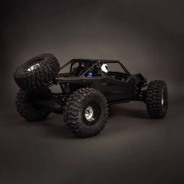 Radio-controlled car models: a little black buggy on a dark gray background.