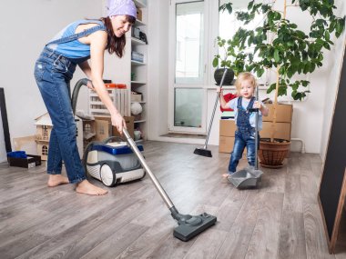 Anne ve kızı mavi kot tulum evde temizlenmiş ve vakum.