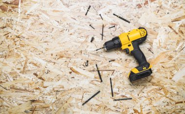 Sarı tornavida, vidalar, yalan Osb arka plan üzerinde bit.