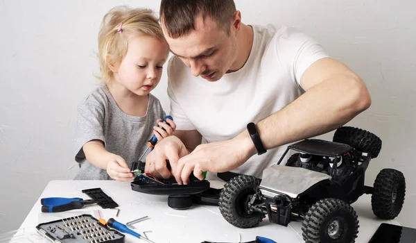 Tempo de família: Pai e filha reparar o rádio rc controlado buggy modelo de carro e levar um blog de vídeo . — Fotografia de Stock