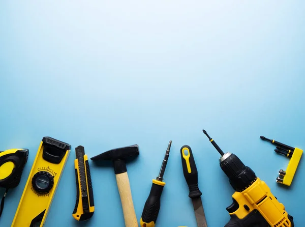 Creative provocation: a flat layout of yellow hand tools on a blue background. — Stock Photo, Image