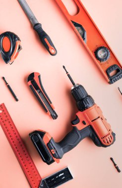 Pembe bir arka plan üzerinde kırmızı el aletleri düz yerleşimi.
