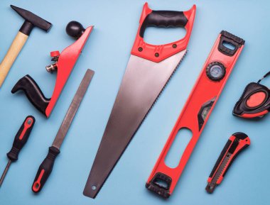 Düz Düzen: İnşaat ve onarım mavi bir arka plan üzerinde kırmızı el aletleri bir dizi.