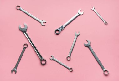 Pembe bir arka plan üzerinde birkaç somun anahtarları.