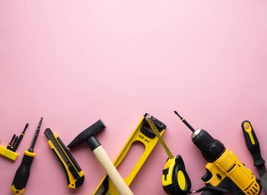 Yaratıcı provokasyon: pembe bir arka plan üzerinde sarı el aletleri düz bir düzen.